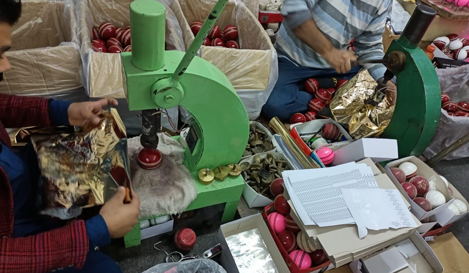 Cricket balls being gold foil stamped by hand in the AJ Sports workshop