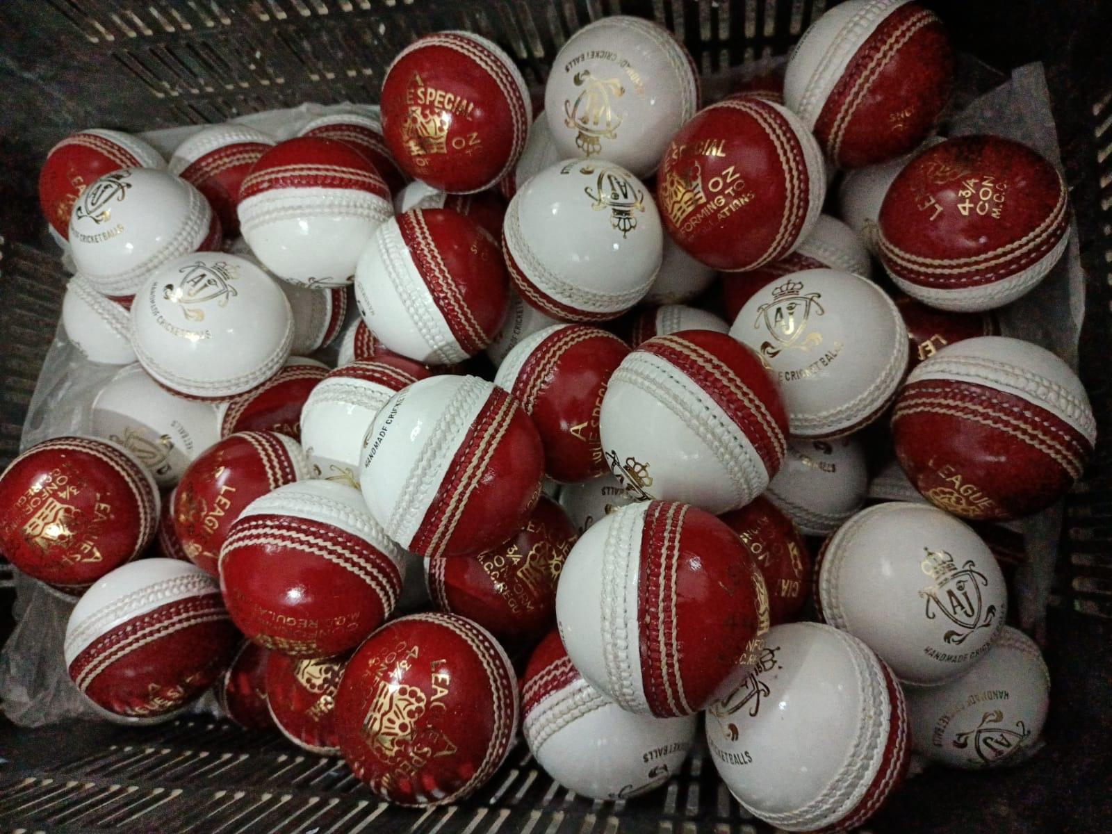 Red and white AJ cricket balls in the workshop